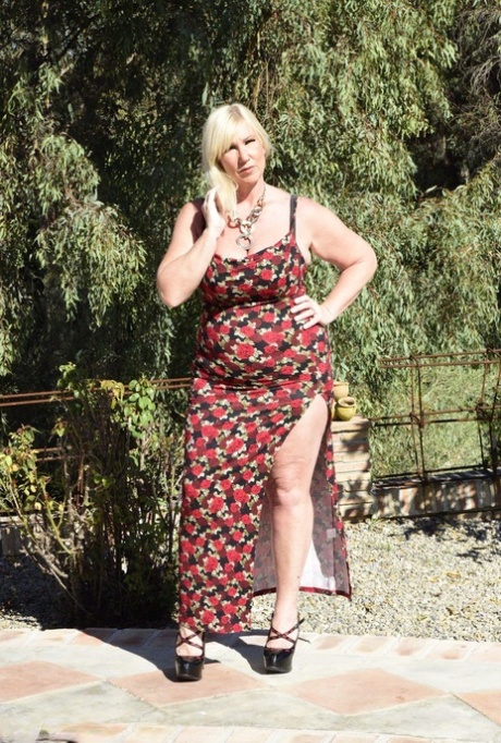 During an outdoor activity, Melody, a fat blonde, looses her big buttocks from a long dress.