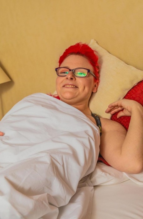 An amateur woman displays her pierced pussy while sporting hair and glasses.