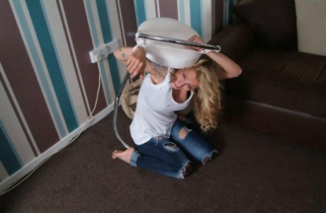 A fully clothed blonde named Katie C struggles and is held in place with rope bindings.