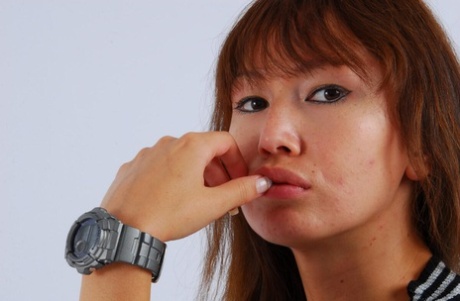 While fully clothed, the Asian redhead Evita wears a grey G-Shock watch.