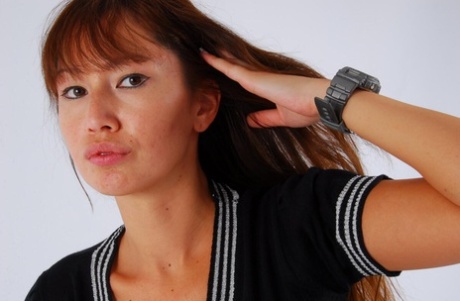 Asian redhead Evita wears a grey G-Shock watch while fully clothed in the back.