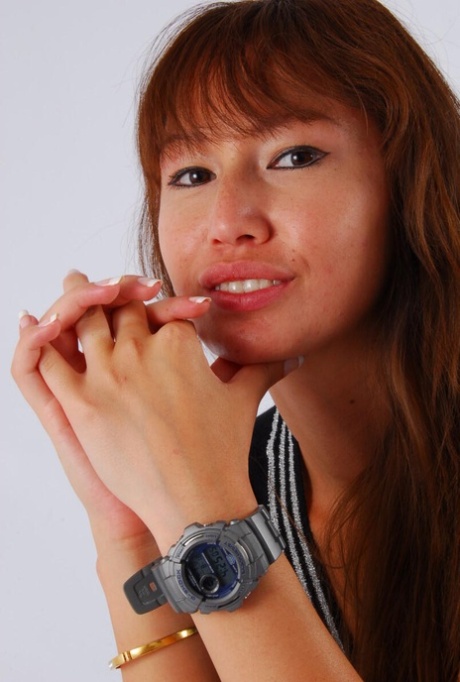 Asian redhead Evita sports a grey G-Shock watch while fully clothed in the back.