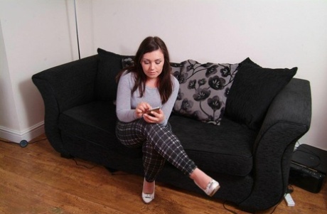 British chick Kacie James is bound with rope on a loveseat while fully clothed