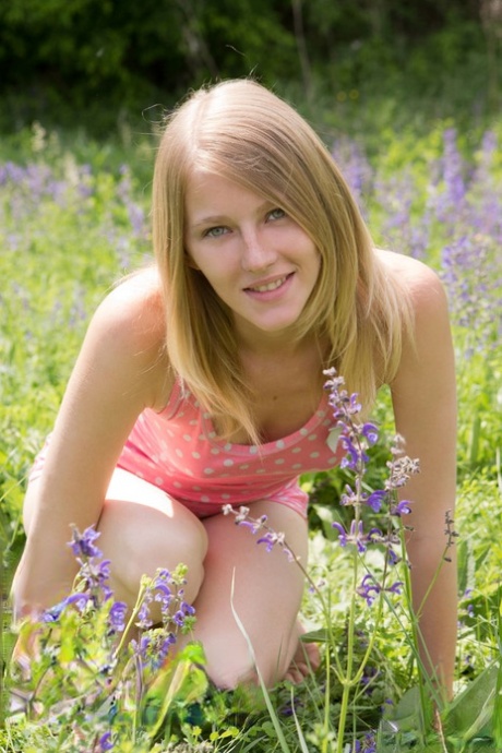 Молодая блондинка Мила полностью раздевается среди полевых цветов