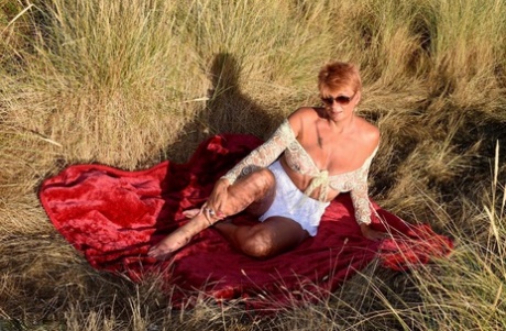 Mature Redhead Dimonty Exposes Her Sagging Tits On A Bench Down By The Sea