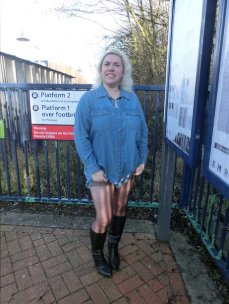 Barby, the older adult woman, exposes her tits and pussy on a train station platform while looking blonde.
