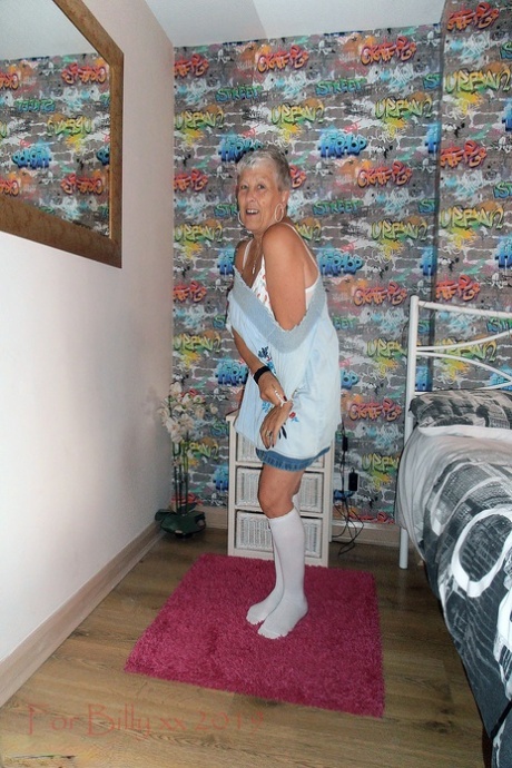 At night, Savana, the granny with silver hair, exposes her body to white knee socks in her bedroom.