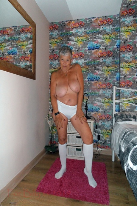 The bedroom of the silver-haired granny Savana is where she sleeps, her clothes revealing herself with white socks on her knees.