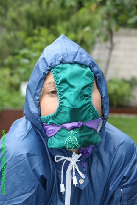 White woman tied to a table in front of the grass with panties draped over her face.