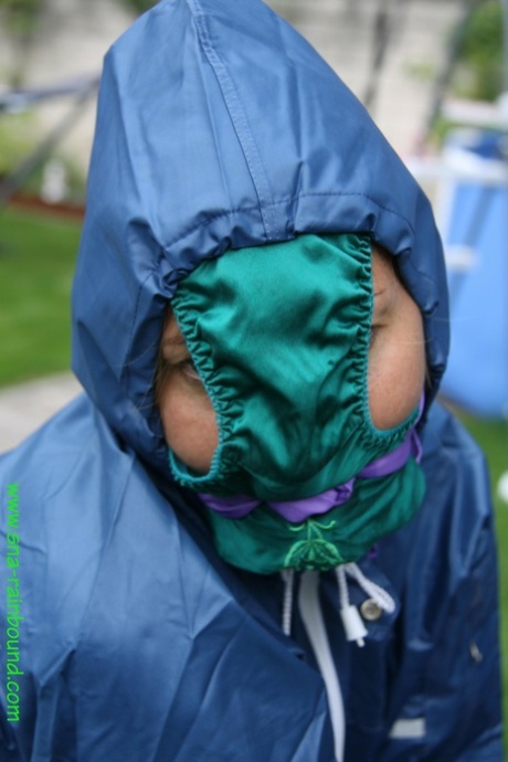 I see a black female tied down at the side of a table in the yard, with panties draped over her face.