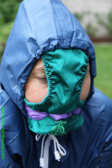 A black female is restrained to a table in a garden, with panties draped over her face.