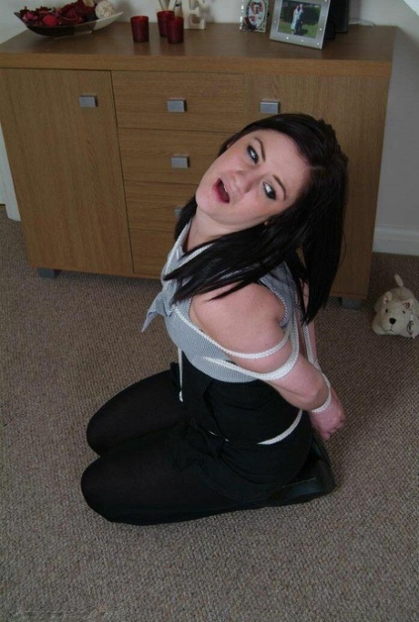 While tied up with rope, Randy Star performs a ball gag on a brunette.