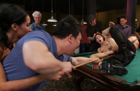 Inside a billiard club, a naked brunette is held back and penetrated.