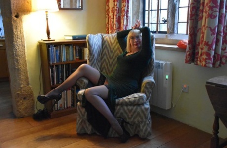 During upskirt action, Barby Slut, an older blonde lady, displays her vagina on a chair.