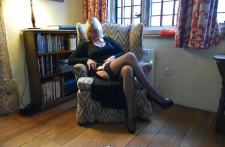 Upskirt action: Old blonde lady Barby Slut puts her vagina on a chair and shows off the act in an upskirt pose.