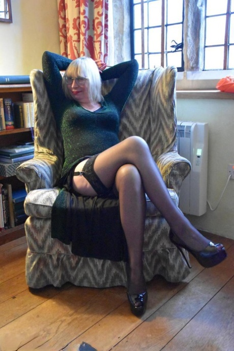As part of her upskirt action, Barby Slut, an older blonde lady, displays her vagina on a chair.