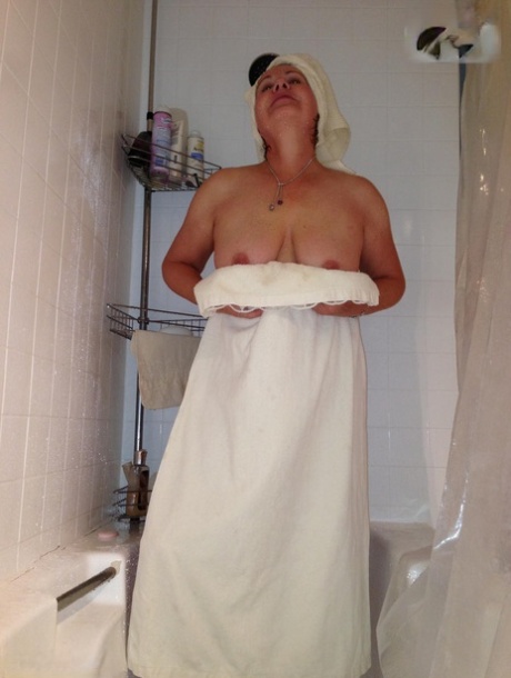 Older amateur Busty Bliss displays her natural tits while taking a shower