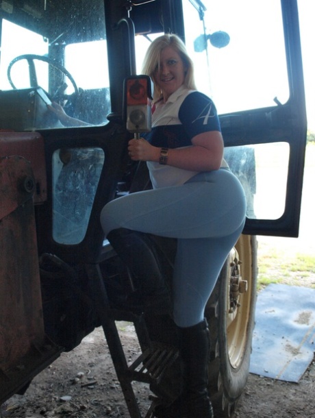 On a farm tractor, an amateur BBW named Samantha wears knee-high black boots.