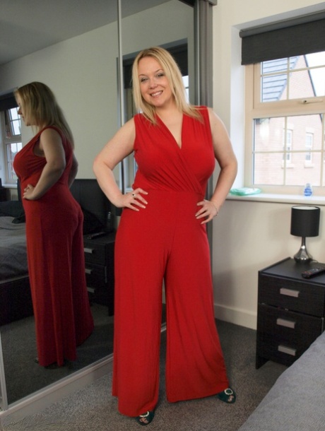 Extending her large tits while removing a red dress, blonde amateur Sindy Bust lets loose.