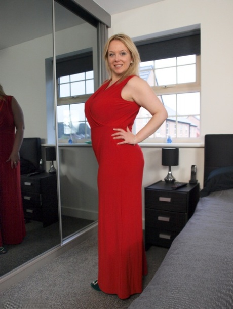 While removing a red dress, blonde amateur Sindy Bust loosens her large pants while wearing loose tits.