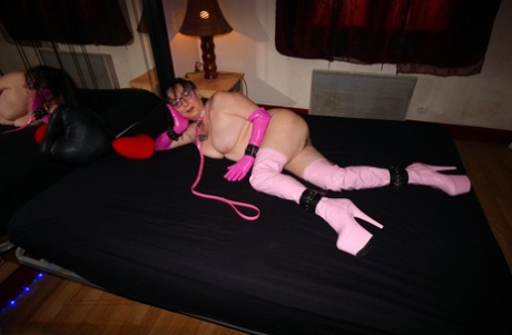 Mary Bitch, an amateur woman, strikes her beaver while wearing pink latex boots.