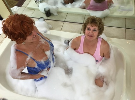 While taking a bubble bath, Busty Bliss engages in lesbian activity as an older adult.