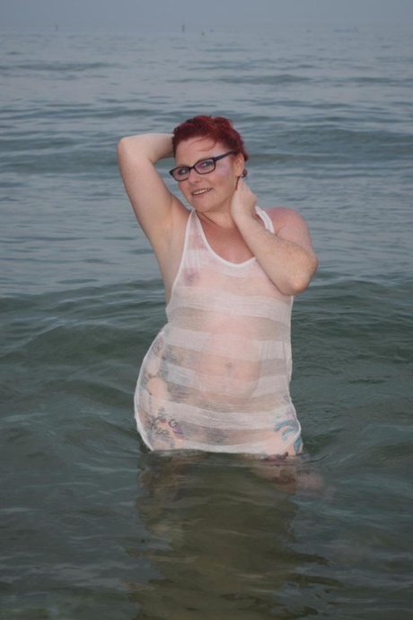 Adult redhead named Mollie Foxxx sweats in the ocean while tattooed.
