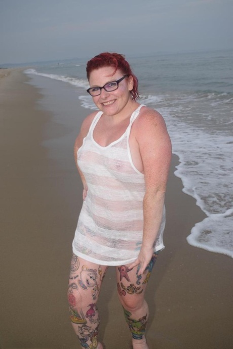 In the ocean, Mollie Foxxx, a young redhead, wets herself with her tattoos.