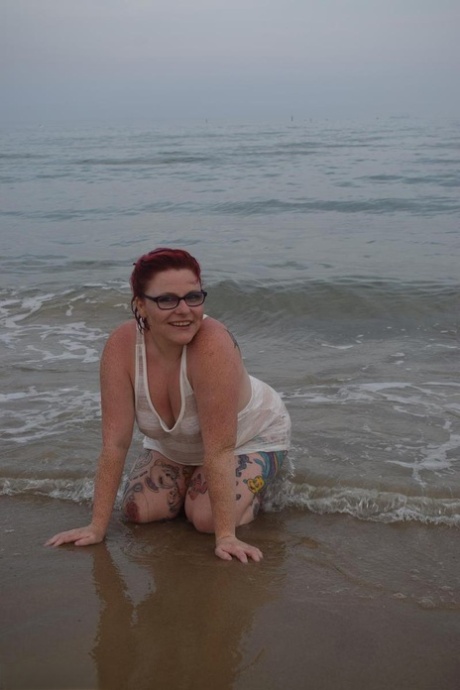 With her tattooed body wet in the ocean, Mollie Foxxx - who is now a mature redhead - can be seen here at seaside.