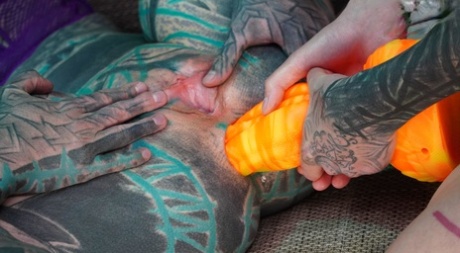 Сильно татуированные девушки участвуют в анальной игре во время секса GGB на диване