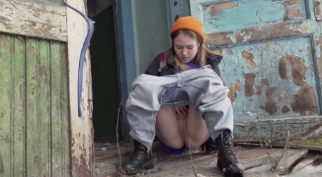 Симпатичная девушка стягивает джинсы для срочного поссать на ступеньках старого дома