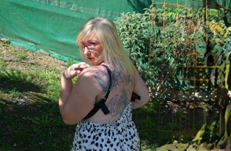 The big fat, mature blonde Melody shows off in a backyard.