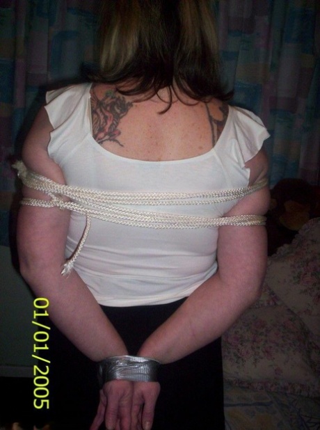 While gagged and roped, the white woman displays her natural tits.