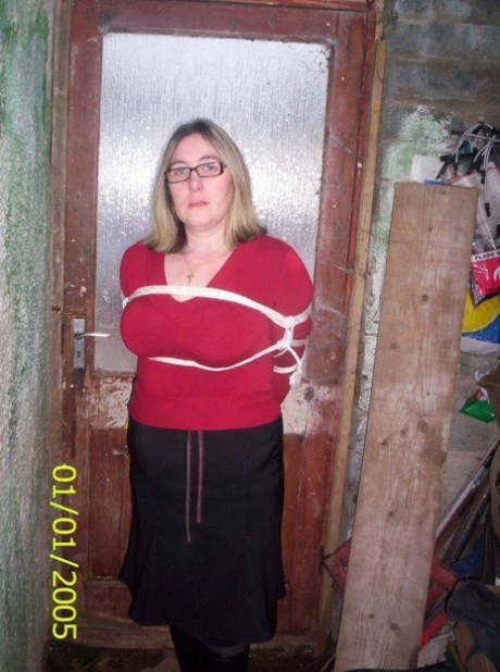 The Caucasian female displays her natural tits while being tied down and roped.