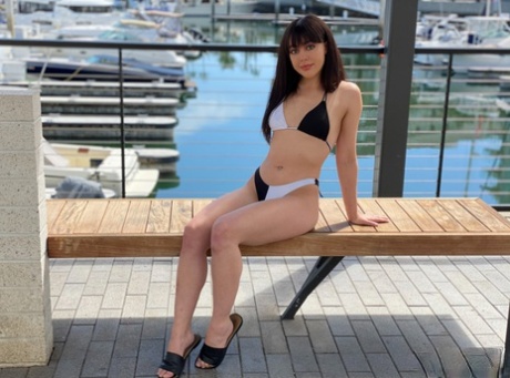 A marina is where Whitney Wright, a brunette girl, models herself in a bikini before having sex.