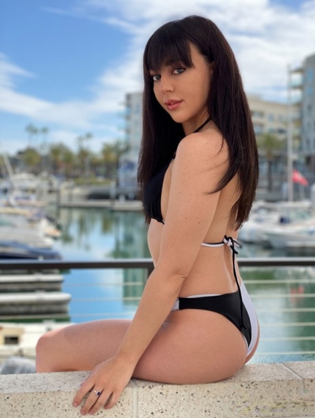 Whitney Wright, the brunette girl, models a bikini at a marina before engaging in sexual activity.