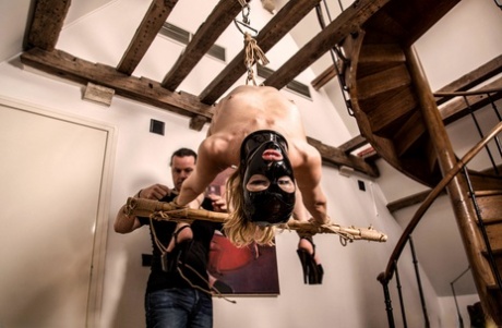 The nude woman known as Dutch Bluebird is seen hanging from a rafter with a hood.