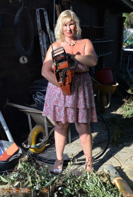 While Melody, a mature blonde and fat woman, is seen wielding a chainsaw, then displays her large breasts.