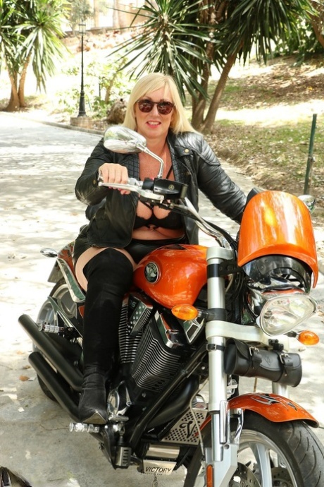 While riding a motorcycle, the mature blonde Melody exposes her large breast tissue.