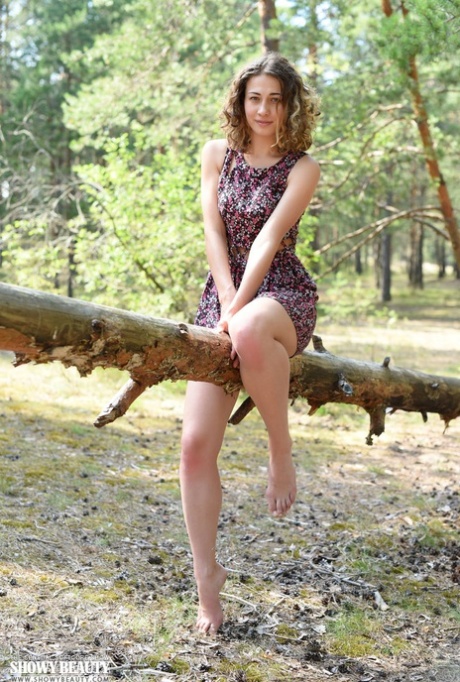 Симпатичная молодая девушка Ари полностью раздевается в лесу