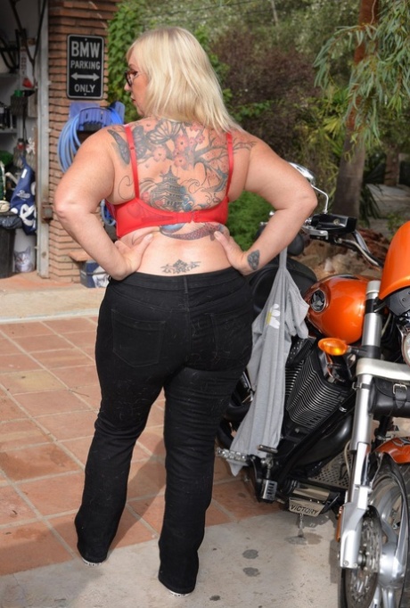 Melody, a blonde who is overweight and loses her top, exits her motorcycle without clothing.