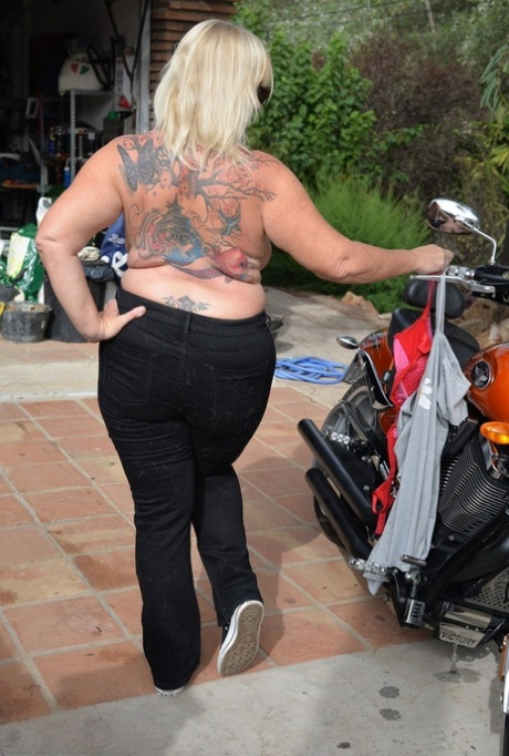 As she gets off her motorcycle, Melody leaves the motorcycle behind, looking overly overweight and without a top.