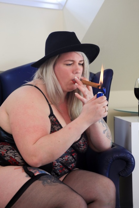 First, blonde BBW Bonie lights up the cigar before going shirtless in this black hat.