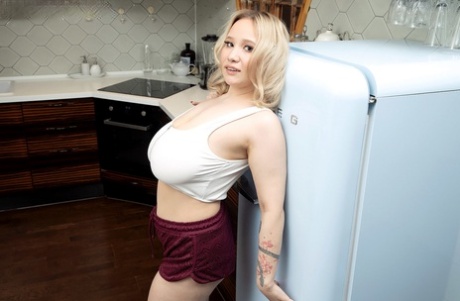 In the kitchen, natural blonde Katie Rose unleashes her massive breasts.