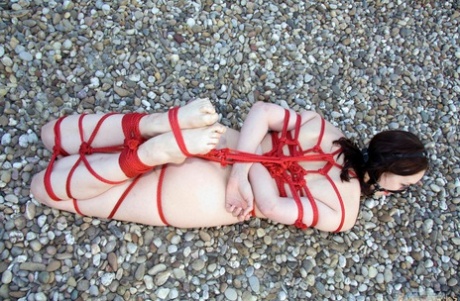 Left alone on a rooftop, this naked woman is tied up with red rope and left naked all alone.