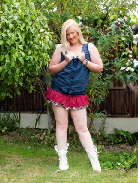 In a backyard, the overweight blonde Samantha displays her breasts and grabs at random.