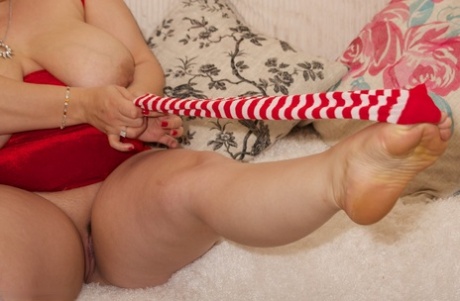 The older blonde BBW wears candy cane knee socks with her pink pussy.