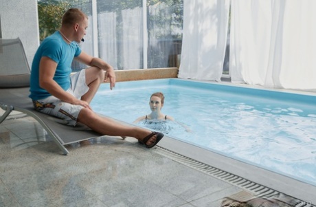 After consuming an indoor pool, the young beauty rests on a lounge chair and enjoys spending time there before engaging in sexual activity.