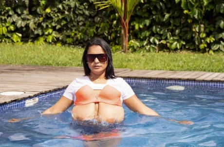 Swimsuiters: Brunette MILF Kim Beltran reveals her huge breasts in the pool area.