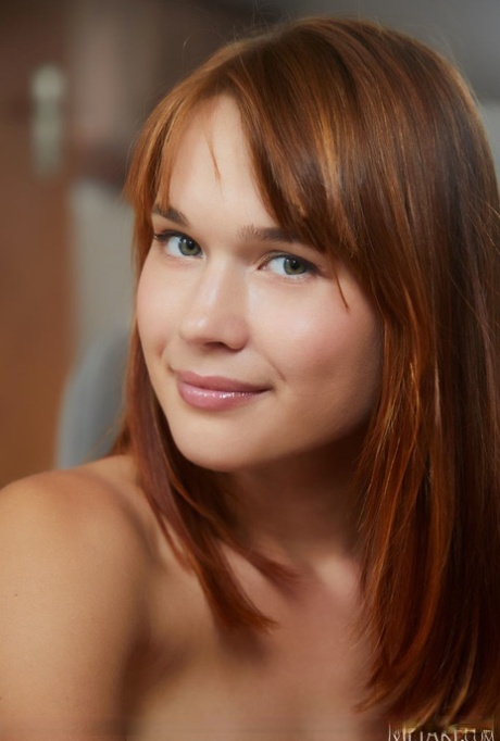 A young redhead named Zaky releases her charming figure from a kitchen cover.